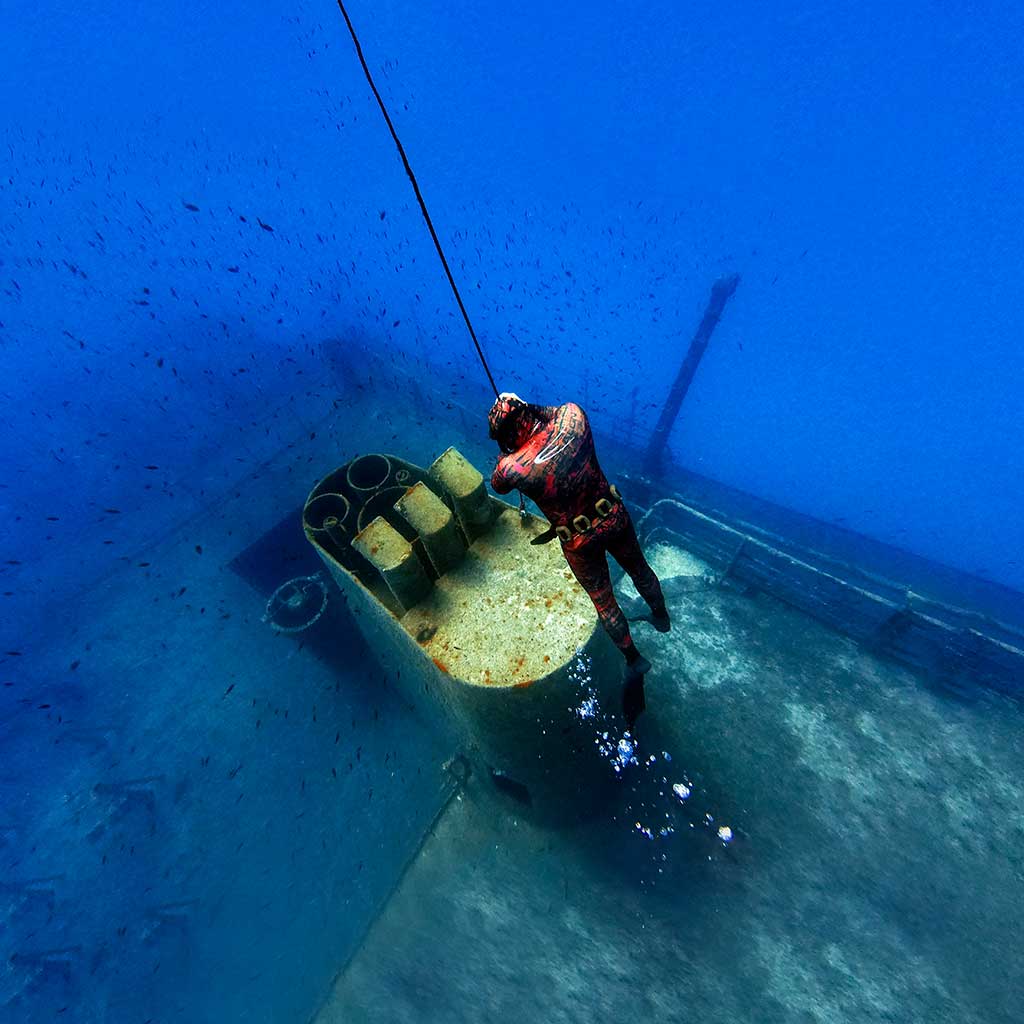 A freediver Freediving in Malta on the top of the chimney of a shipwreck