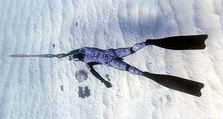 Freediver descending in constant weight towards a drop off