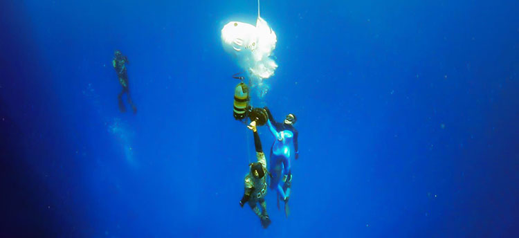 Freedivers ascending in a freediving sled