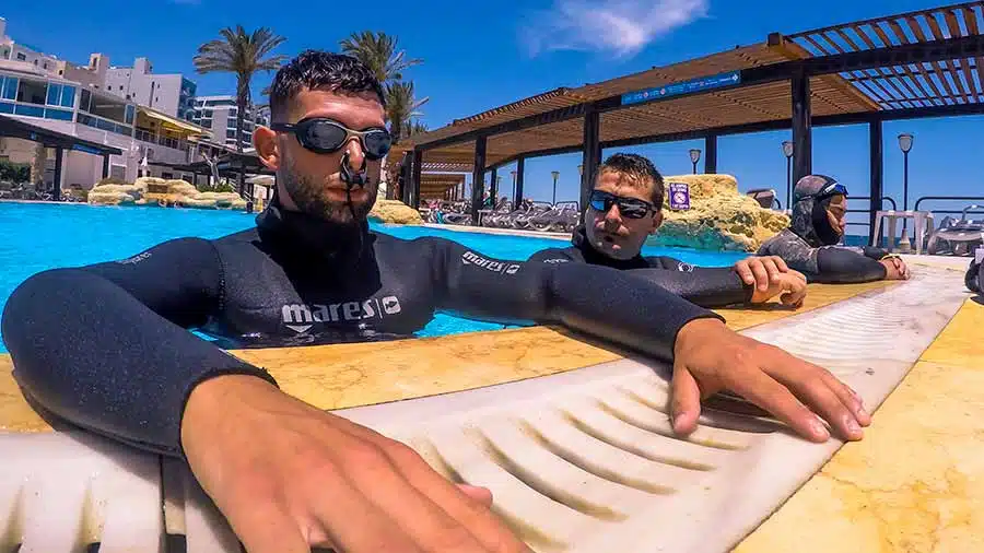 Freediver in the pool with noseclips and googles on ready to start a static apnea course in Malta