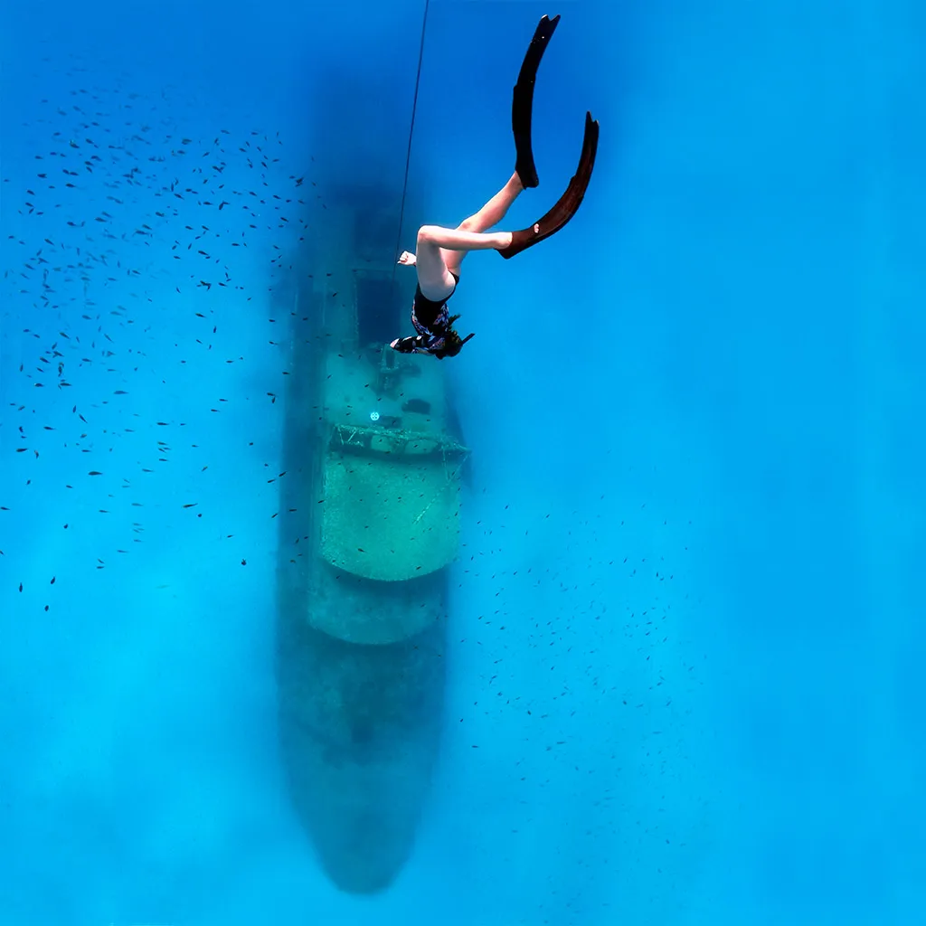 A female freediver in Comino descending the line towards a shipwreck