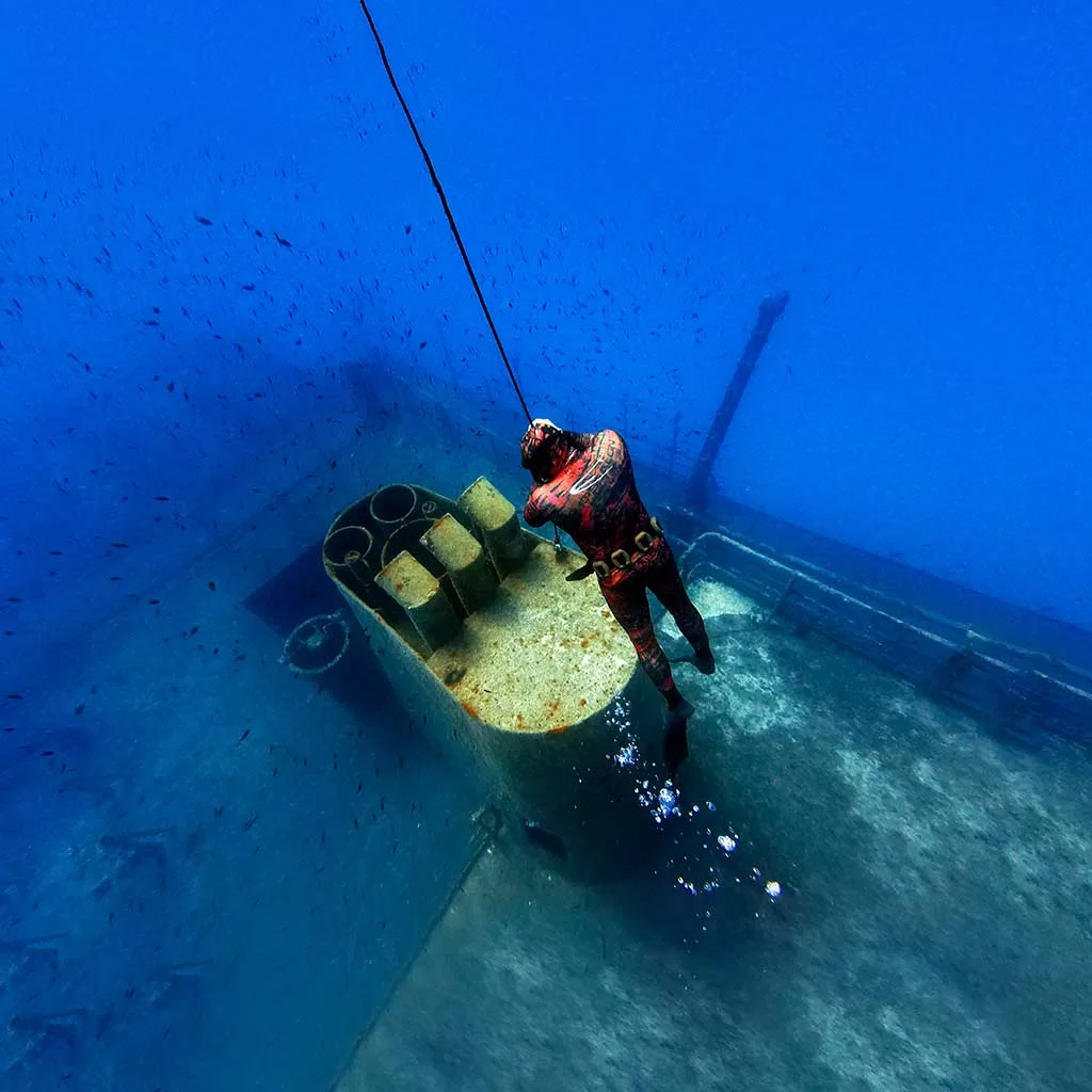 A freediver Freediving in Malta on the top of the chimney of a shipwreck
