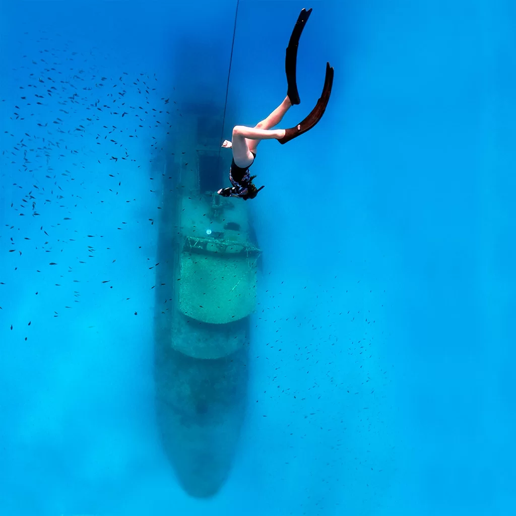A female freediver in Comino descending the line towards a shipwreck